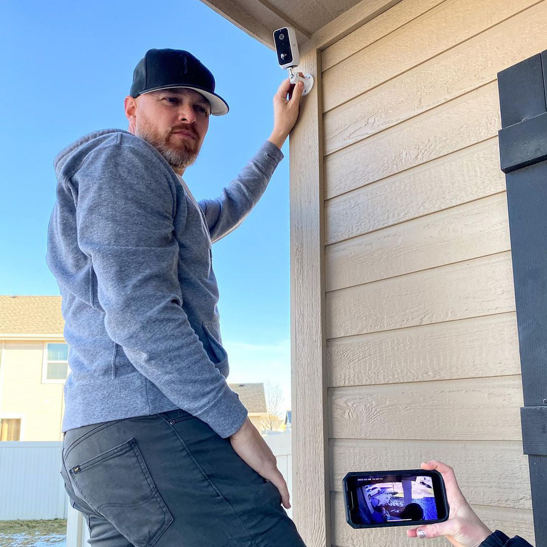 Man installing Feit Electric smart outdoor security camera