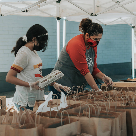 people packing bags with food items
